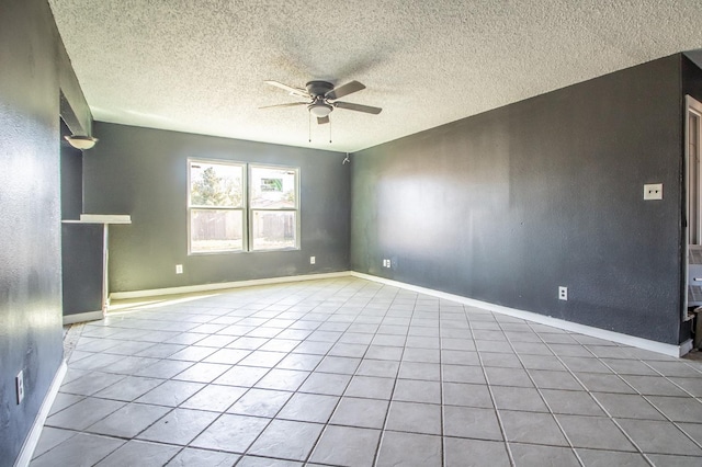 tiled spare room featuring a textured ceiling and ceiling fan