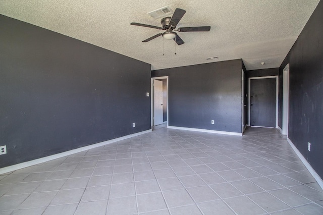 empty room featuring a textured ceiling, ceiling fan, and light tile patterned flooring