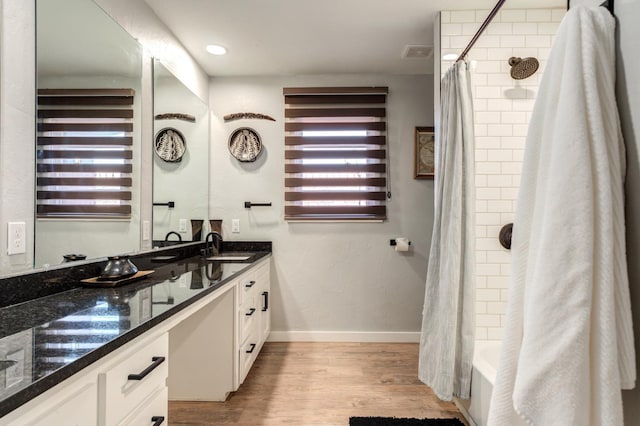 bathroom featuring vanity, hardwood / wood-style flooring, and shower / bathtub combination with curtain