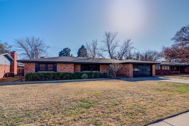 ranch-style home featuring a garage and a front yard