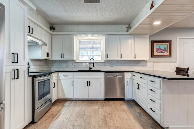 kitchen featuring white cabinetry, stainless steel appliances, sink, and light wood-type flooring