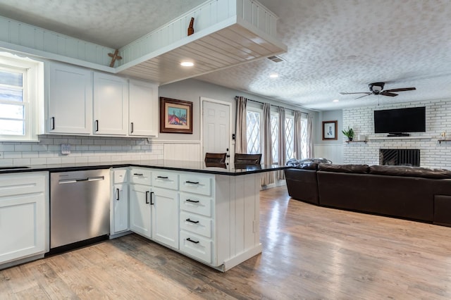 kitchen with white cabinetry, a healthy amount of sunlight, stainless steel dishwasher, and light hardwood / wood-style flooring