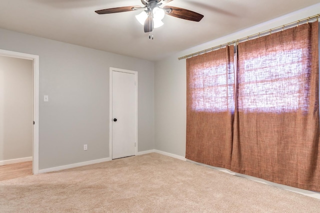 empty room featuring light colored carpet and ceiling fan