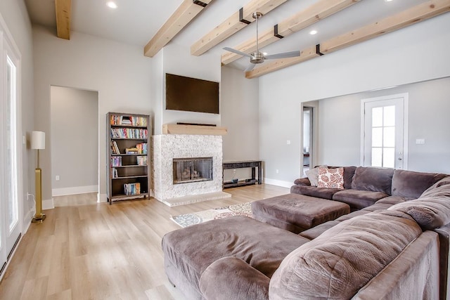 living room with beamed ceiling, ceiling fan, and light hardwood / wood-style flooring