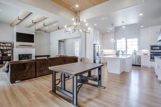 dining space featuring beamed ceiling, wood ceiling, and light hardwood / wood-style flooring