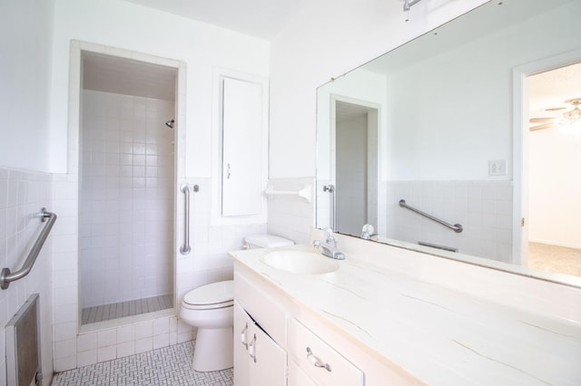 full bath with toilet, tile walls, tiled shower, and vanity