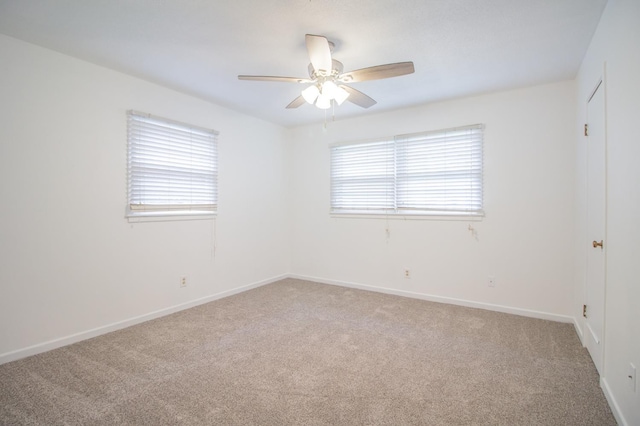 empty room featuring ceiling fan, baseboards, light carpet, and a healthy amount of sunlight