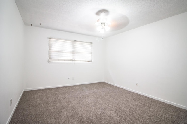 empty room featuring baseboards, a textured ceiling, a ceiling fan, and carpet floors