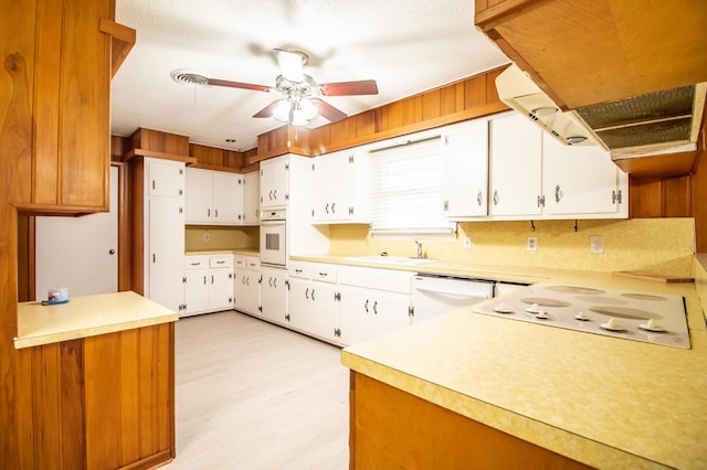 kitchen featuring light countertops, ceiling fan, a sink, and white appliances
