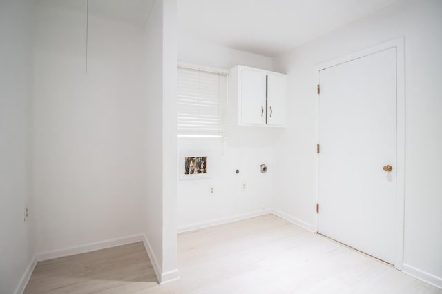 clothes washing area with light wood-type flooring, baseboards, hookup for a washing machine, and cabinet space