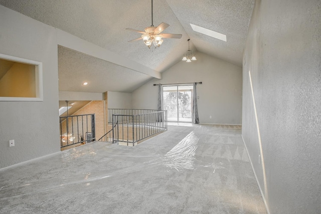 bonus room with ceiling fan, light colored carpet, vaulted ceiling with skylight, and a textured ceiling