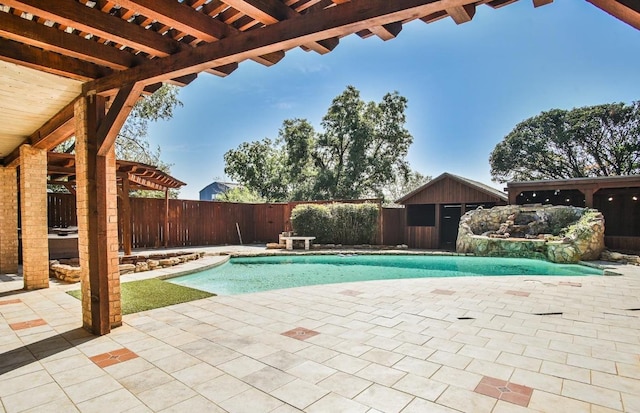 view of swimming pool featuring a patio, pool water feature, and an outdoor structure