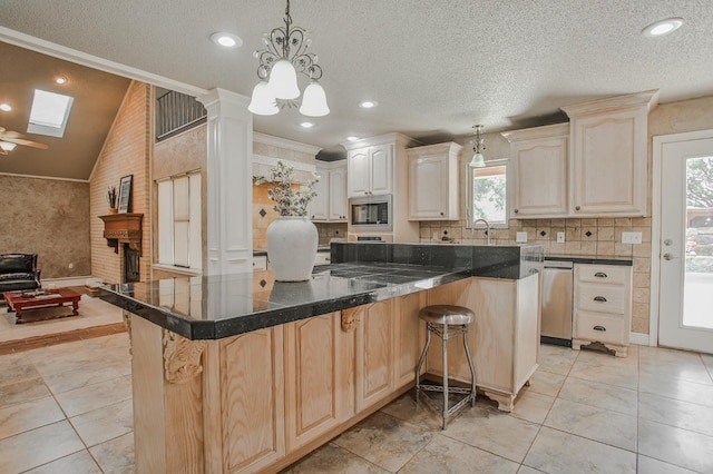 kitchen featuring lofted ceiling with skylight, light tile patterned flooring, a breakfast bar area, hanging light fixtures, and stainless steel appliances