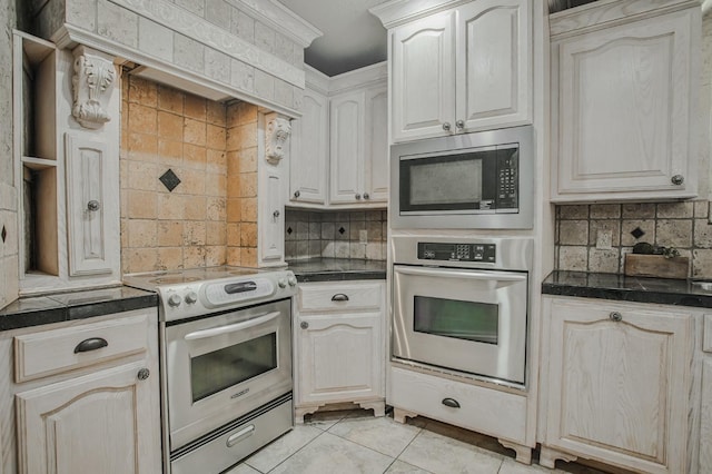 kitchen with backsplash, ornamental molding, light tile patterned flooring, and appliances with stainless steel finishes