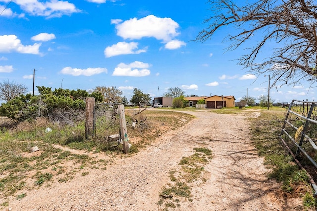 view of road featuring a rural view, driveway, and a gated entry