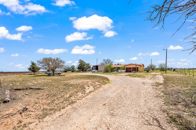 view of road with a rural view and dirt driveway