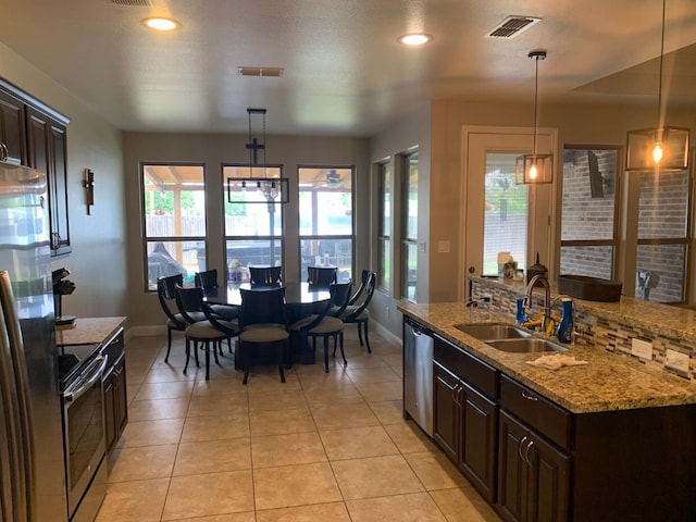 kitchen with dark brown cabinetry, appliances with stainless steel finishes, sink, and hanging light fixtures