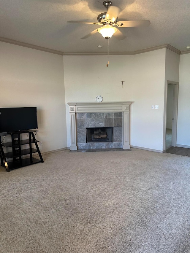 unfurnished living room with crown molding, a textured ceiling, ceiling fan, a fireplace, and carpet