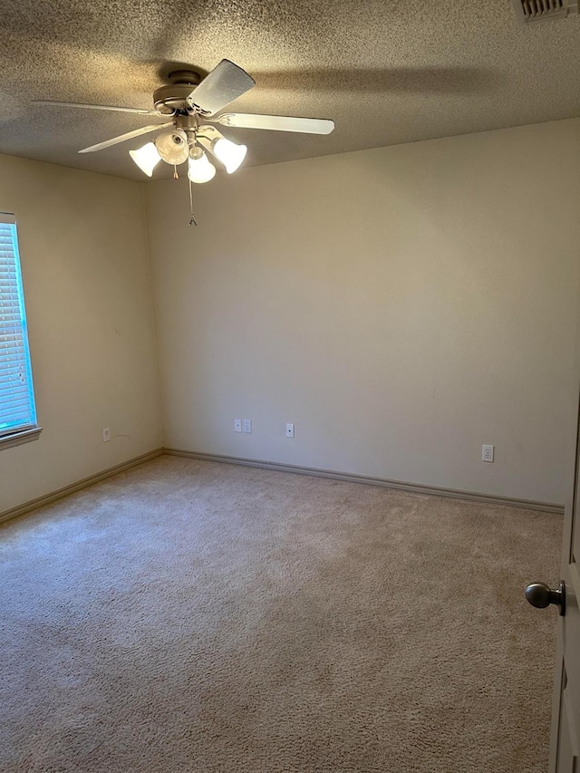 spare room featuring ceiling fan, carpet floors, and a textured ceiling