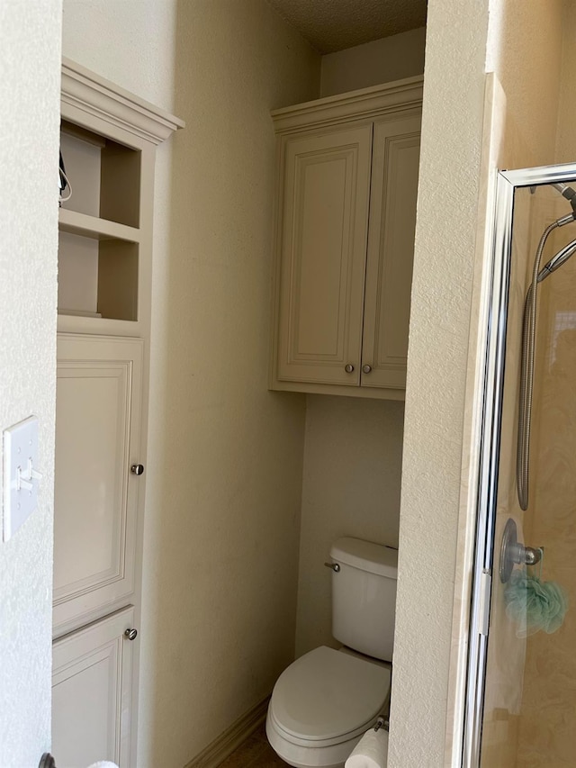 bathroom with an enclosed shower and toilet