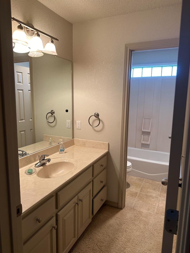 full bathroom featuring vanity, a textured ceiling, shower / washtub combination, and toilet