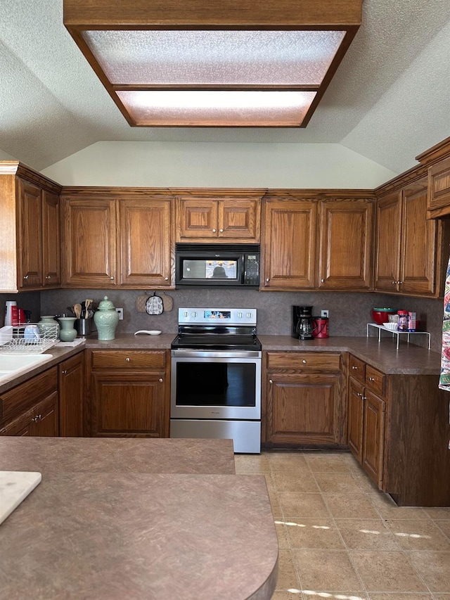 kitchen featuring stainless steel range with electric stovetop, lofted ceiling, and a textured ceiling