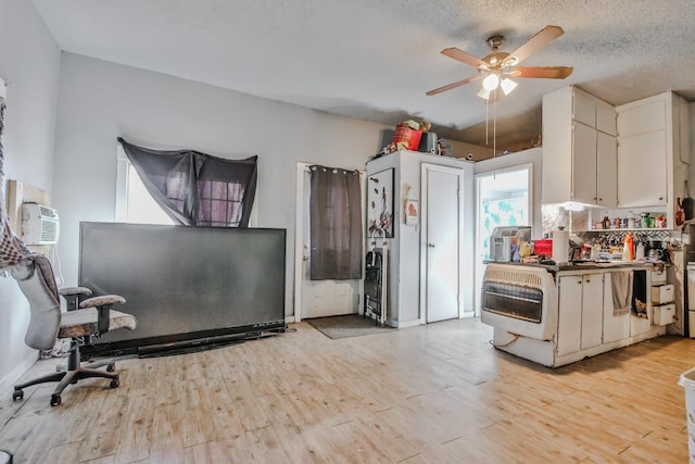 kitchen featuring white cabinetry, ceiling fan, a textured ceiling, and light wood-type flooring