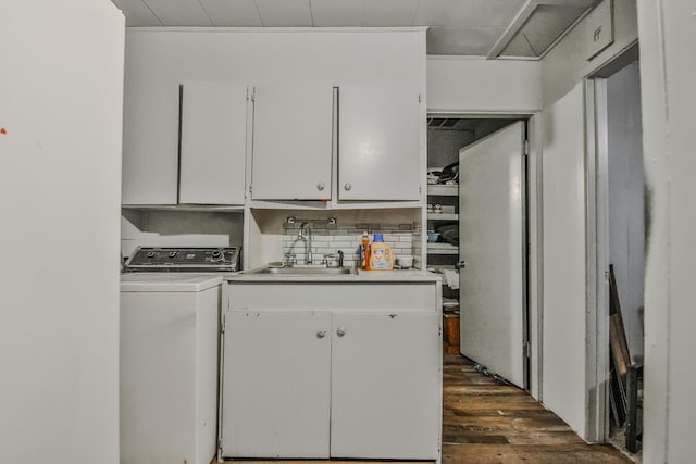 kitchen featuring dark hardwood / wood-style flooring, washer / dryer, sink, and white cabinets