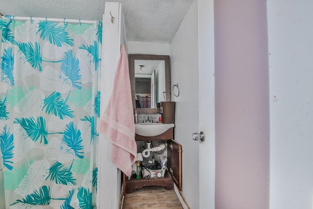 bathroom featuring sink, hardwood / wood-style floors, a textured ceiling, and a shower with curtain