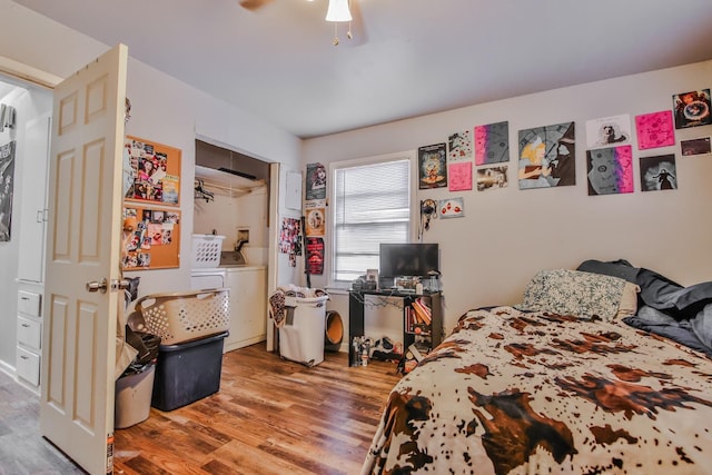 bedroom featuring ceiling fan, washing machine and clothes dryer, and hardwood / wood-style floors