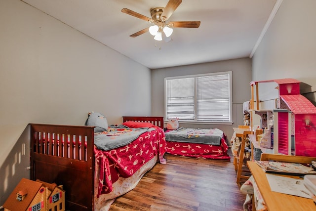 bedroom with ceiling fan, ornamental molding, and dark hardwood / wood-style flooring