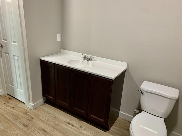 bathroom featuring vanity, toilet, and hardwood / wood-style floors