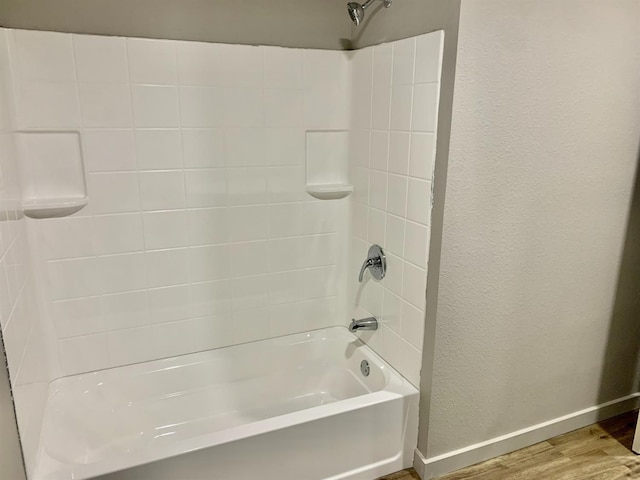 bathroom with wood-type flooring and  shower combination