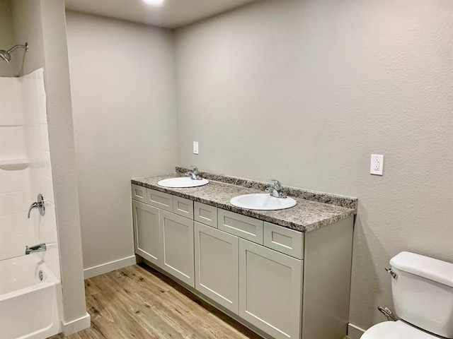 full bathroom with hardwood / wood-style flooring, vanity, shower / bathing tub combination, and toilet