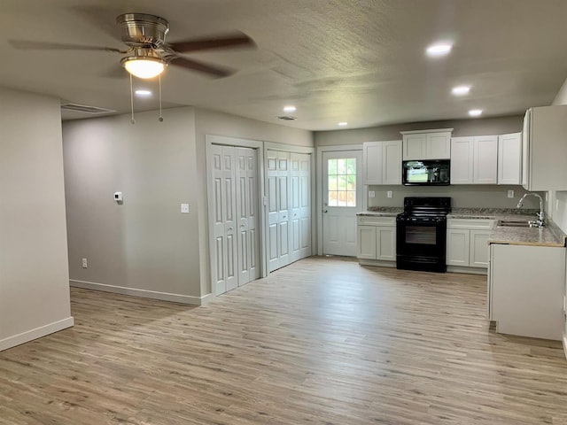 kitchen featuring black appliances, sink, white cabinets, ceiling fan, and light hardwood / wood-style floors