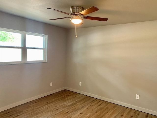 spare room with ceiling fan and light wood-type flooring