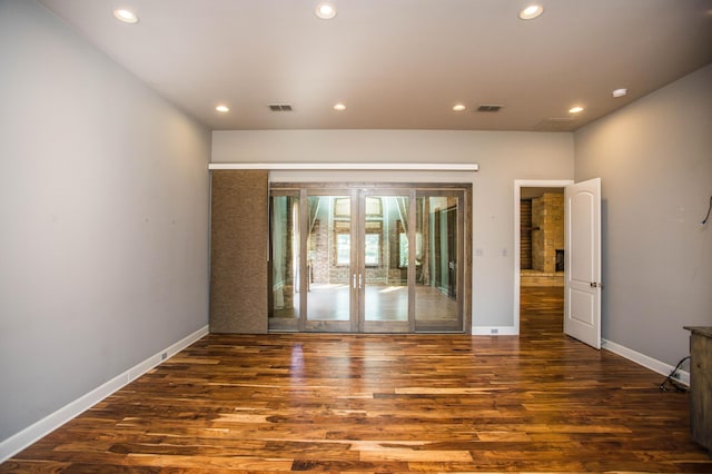 empty room featuring dark wood-type flooring, recessed lighting, and visible vents