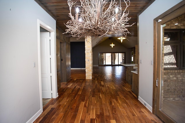 corridor featuring dark wood-style flooring, wooden ceiling, and baseboards