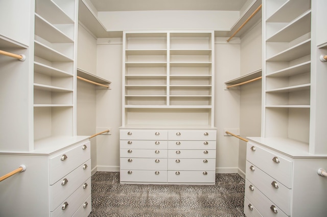 walk in closet featuring dark carpet