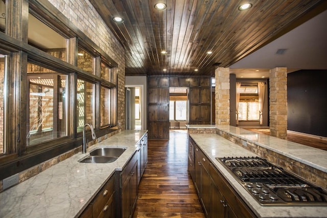 kitchen with dark brown cabinets, a sink, wood ceiling, and stainless steel gas stovetop