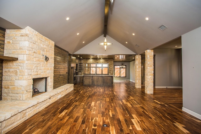 unfurnished living room featuring baseboards, visible vents, dark wood finished floors, beamed ceiling, and a fireplace