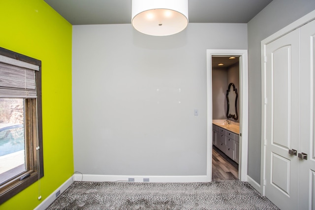 empty room featuring baseboards and a sink