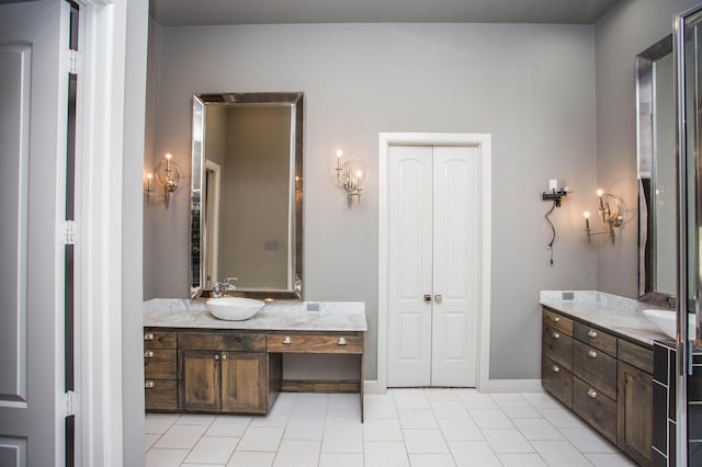 full bathroom featuring a closet, tile patterned flooring, vanity, and baseboards