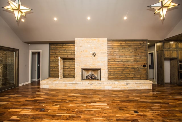 unfurnished living room with dark wood-style floors, high vaulted ceiling, and a stone fireplace