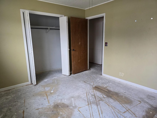 unfurnished bedroom with crown molding, a textured ceiling, and a closet