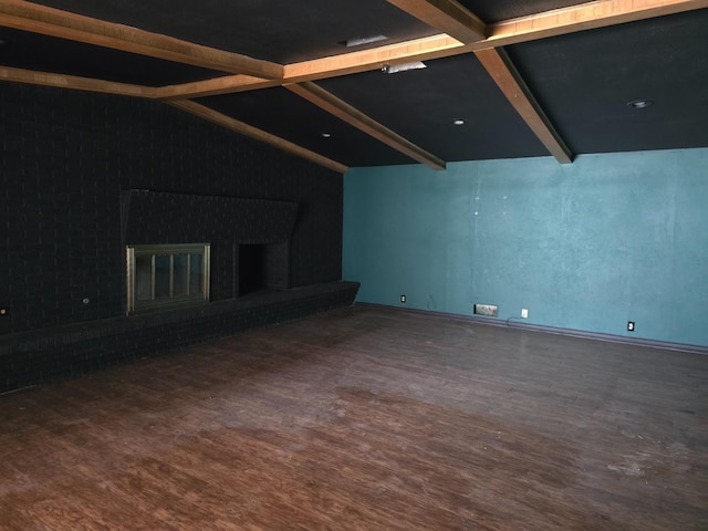 unfurnished living room featuring hardwood / wood-style flooring and vaulted ceiling with beams