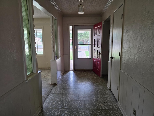 doorway to outside with crown molding and a textured ceiling