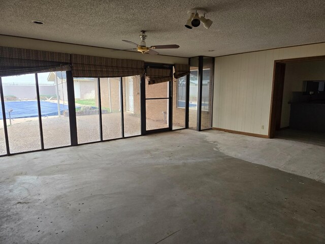 unfurnished sunroom with ceiling fan