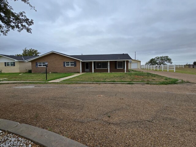 single story home featuring a garage and a front lawn