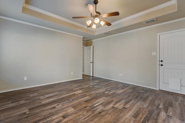 empty room with a raised ceiling, crown molding, ceiling fan, and dark hardwood / wood-style flooring